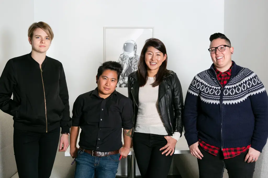 A group of queer leaders, standing and smiling while looking directly at the camera.